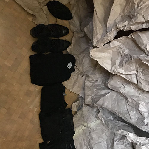 neatly folded clothes in a line on the floor inside the box